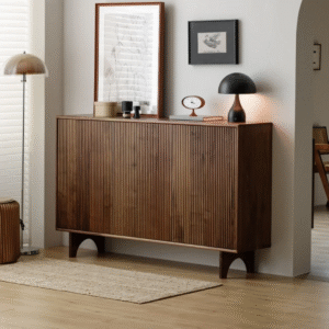 Premium fluted wooden shoe sideboard by WoodBee Craft featuring a 3-door dark walnut frame, vertical fluted paneling, and unique arched legs in a minimalist room.