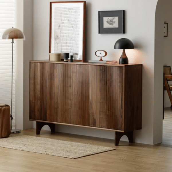 Premium fluted wooden shoe sideboard by WoodBee Craft featuring a 3-door dark walnut frame, vertical fluted paneling, and unique arched legs in a minimalist room.
