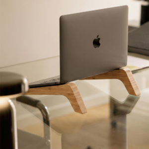 Handcrafted wooden laptop riser stand on glass desk by WoodBee Craft